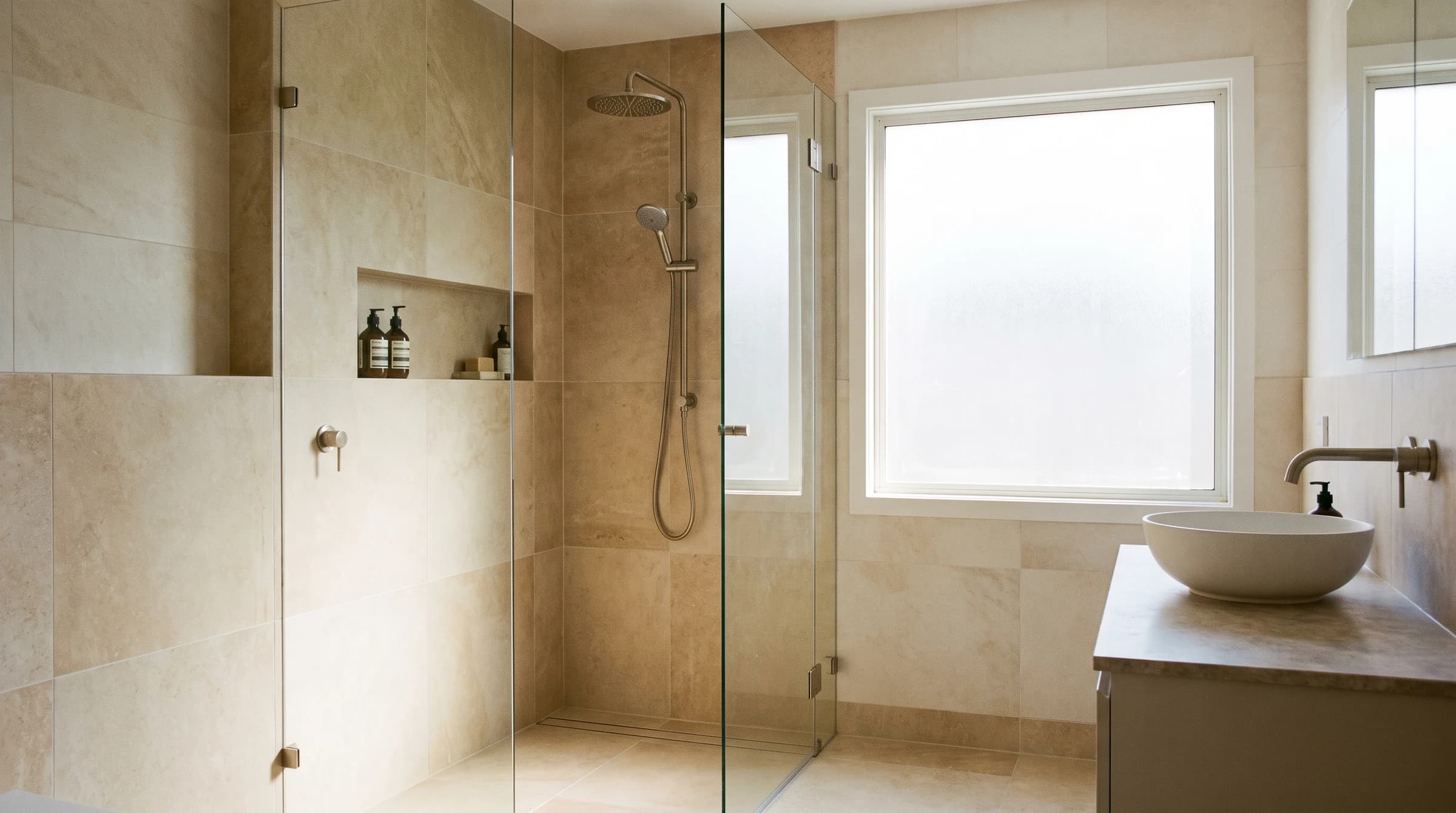 Finished bathroom with glass shower, large-format tile, and brushed fixtures