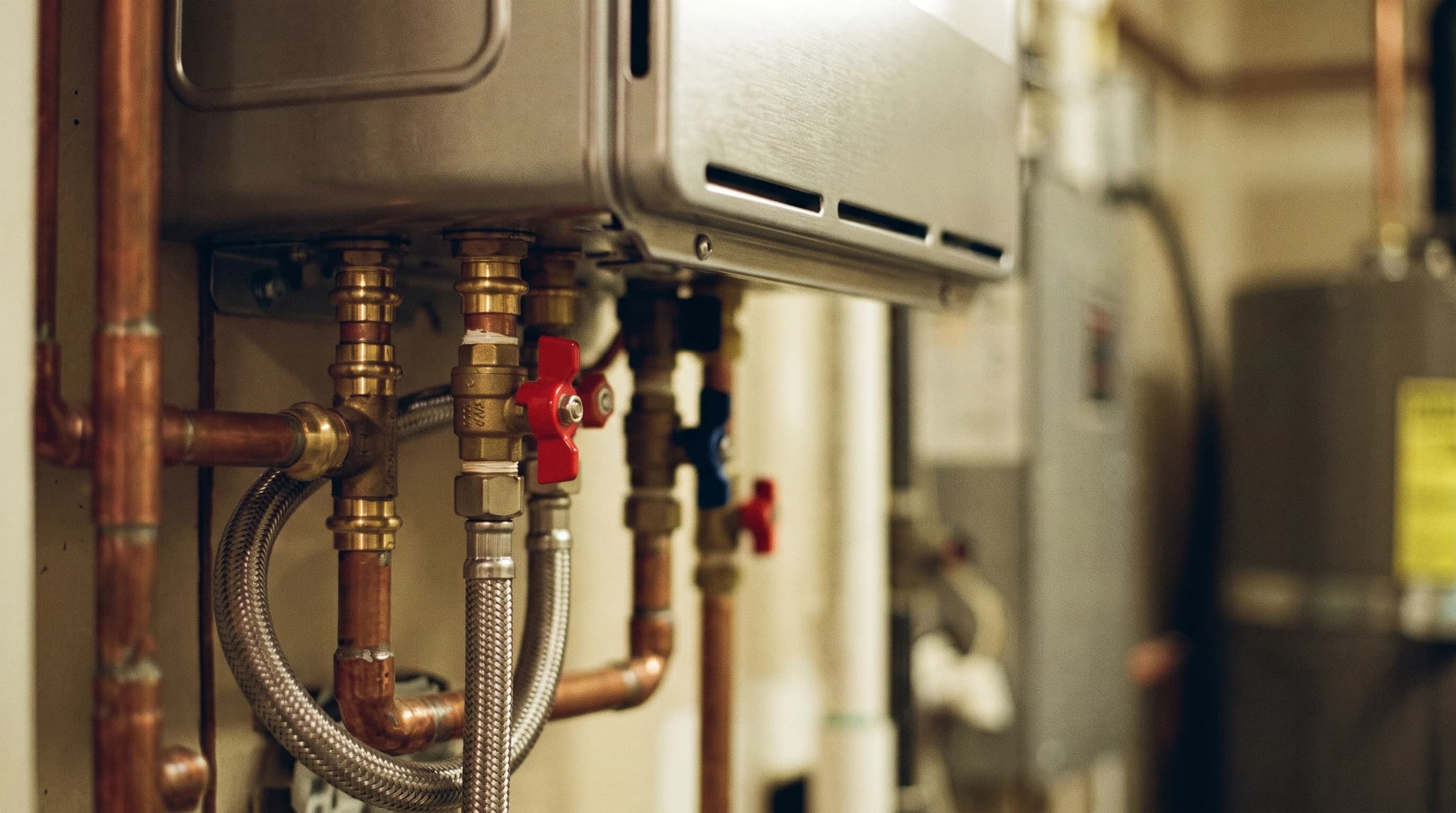 Copper press unions and valves at a tankless connection in macro detail